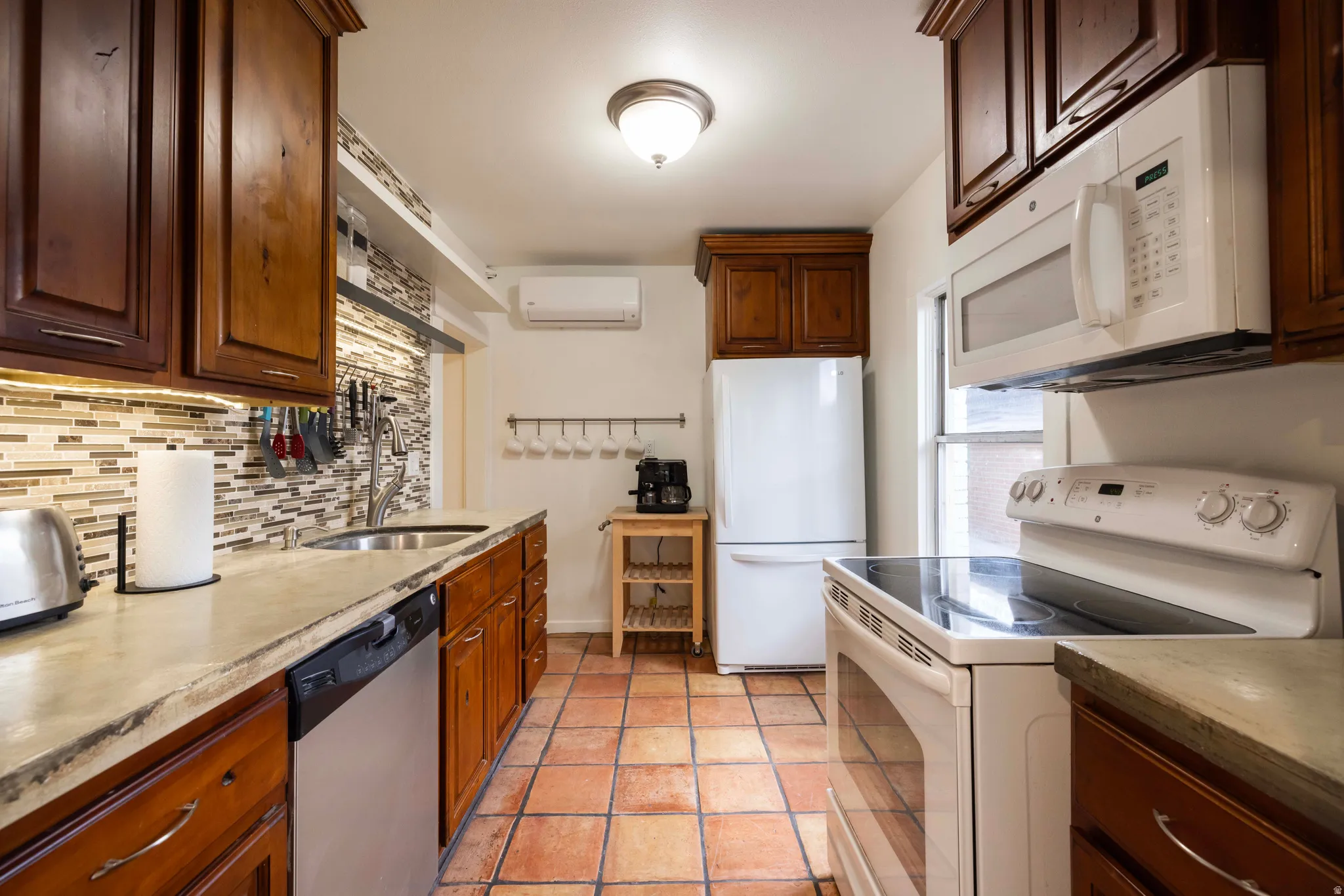 Apt. #3 Kitchen featuring alder wood cabinets, cement counter tops, tiled floor and backsplash