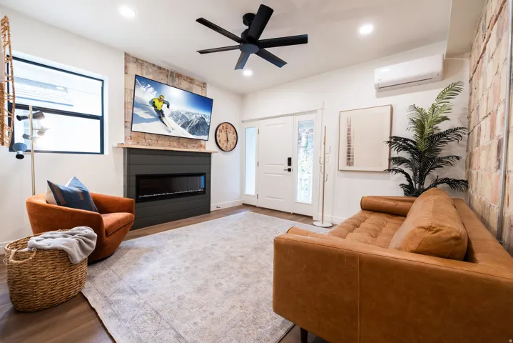Apt. #2 Family Room with a fireplace and a mini-split wall unit.