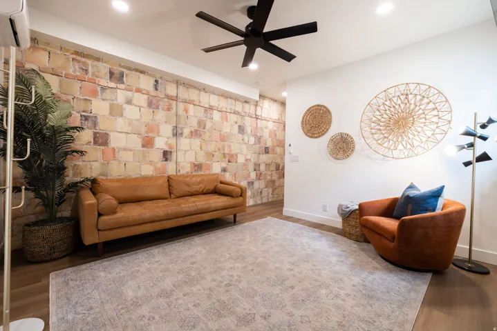 Apt. #2 Family room featuring original rock accent wall, recessed lighting, and wood finished floors