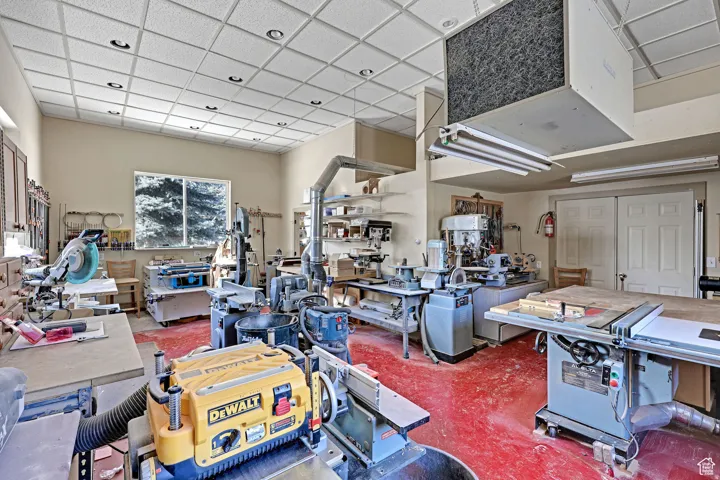 Misc room featuring a workshop area, a paneled ceiling, and a heating unit
