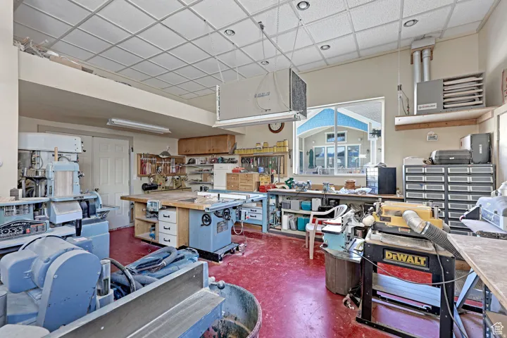 Misc room featuring a paneled ceiling and a workshop area