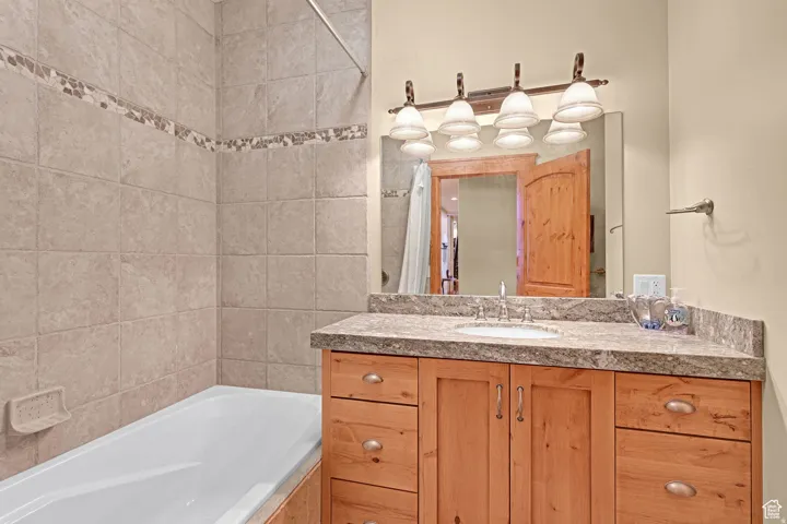 Bathroom with tiled shower / bath and vanity