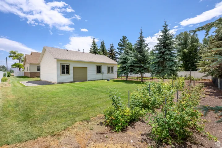 Back of house featuring a garage and a shingled roof