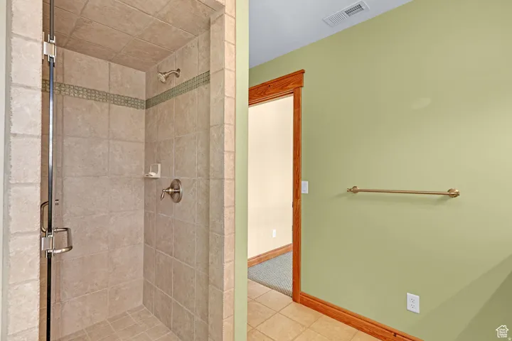 Full bathroom with a shower stall and tile patterned floors