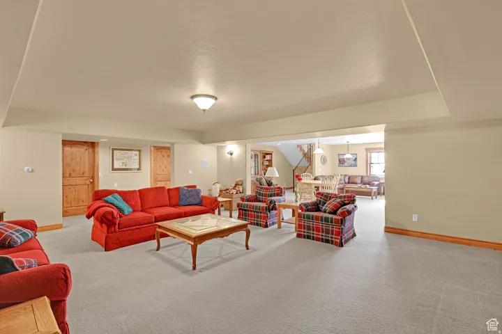 Living area featuring light colored carpet and baseboards