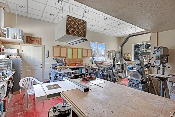Interior space featuring a heating unit, a workshop area, and a paneled ceiling