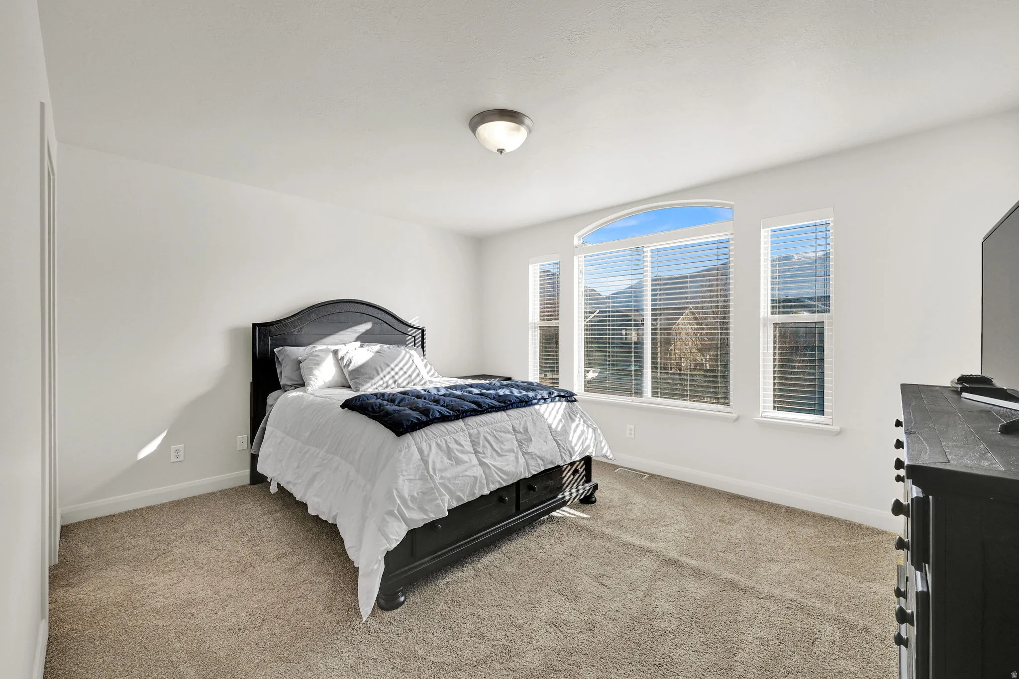 Bedroom featuring light carpet