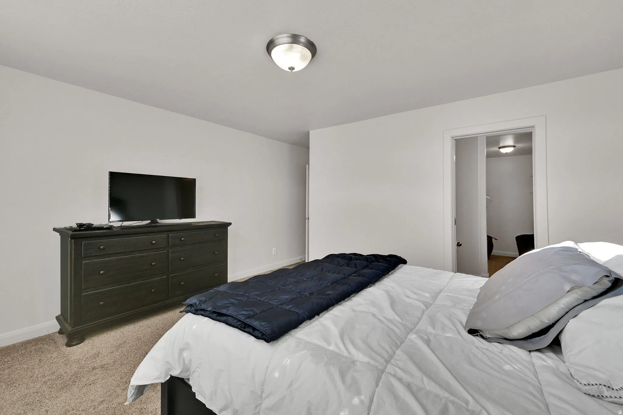 Bedroom featuring light carpet and baseboards