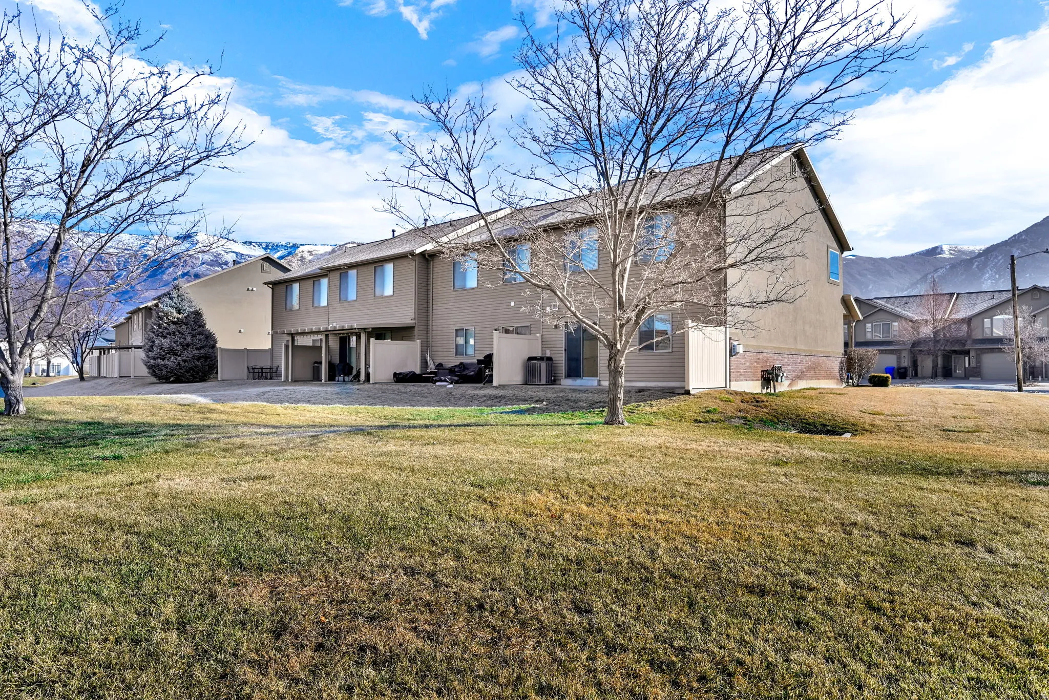 Back of house featuring a lawn, a mountain view, and a patio area