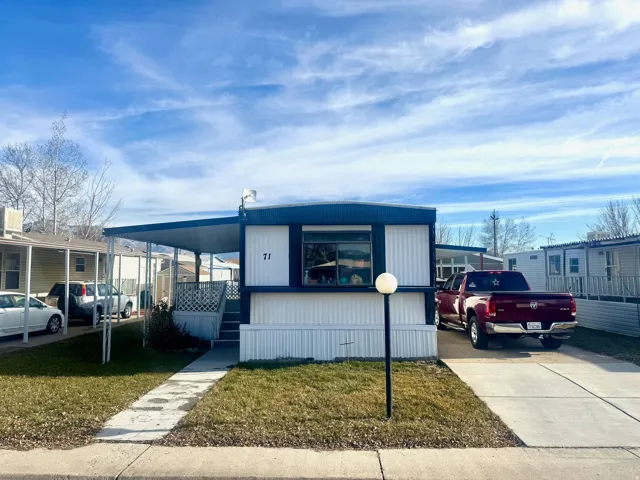 Manufactured / mobile home with a front yard and covered porch