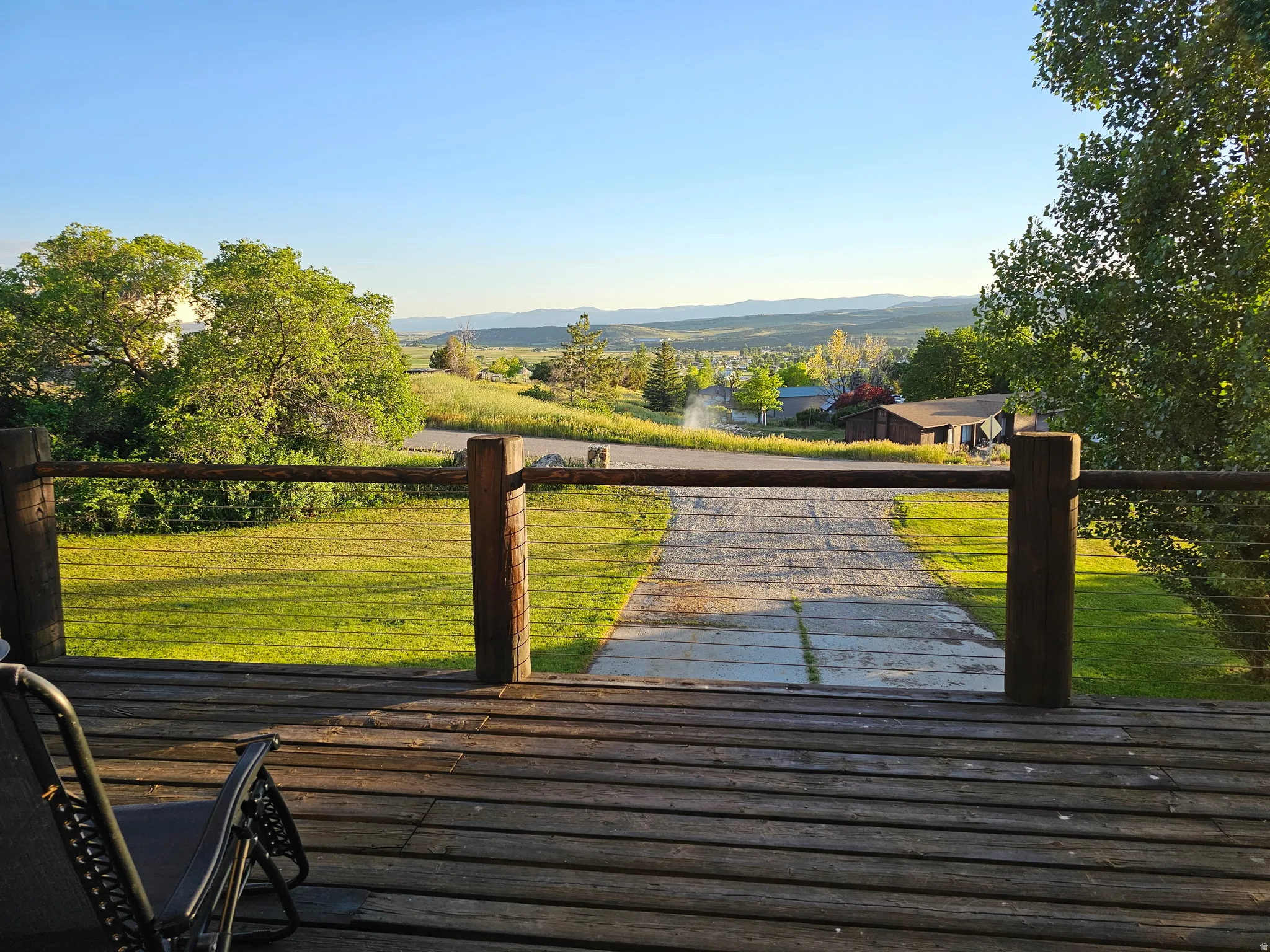 Wooden terrace featuring a mountain view and a yard
