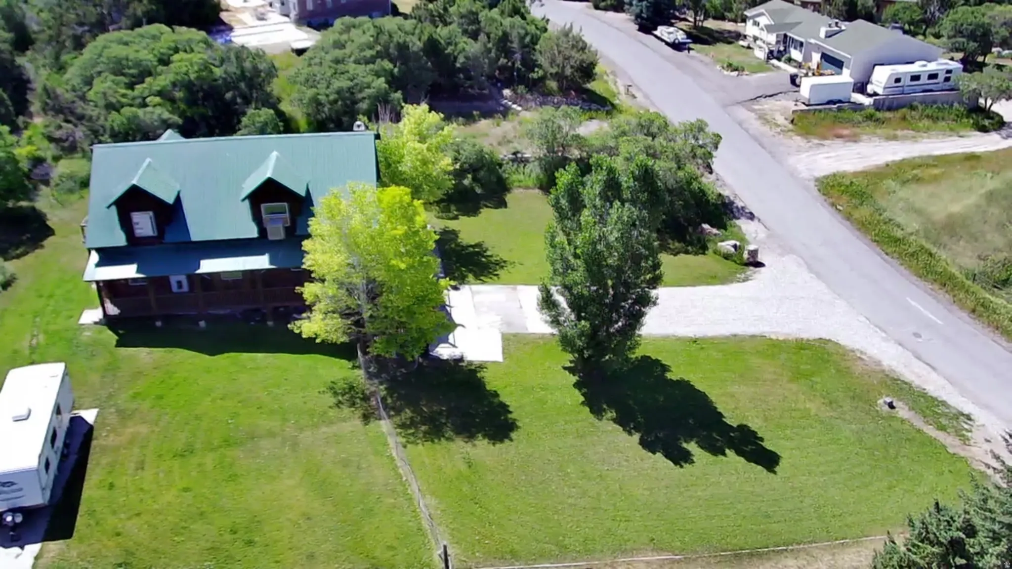 View of subject property with a tree filled landscape