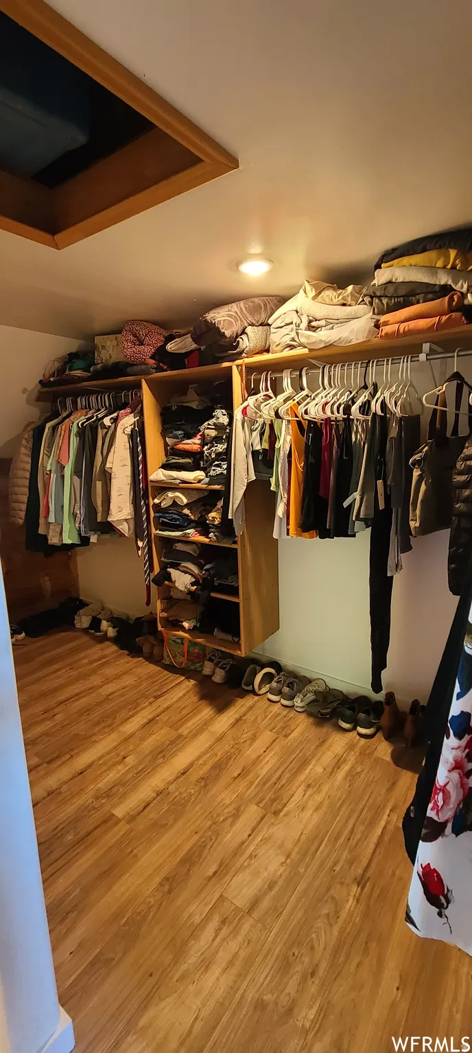 Walk in closet with light wood-type flooring