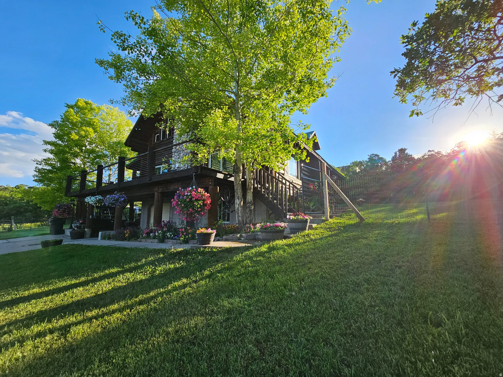 View of property exterior with a wooden deck and a lawn