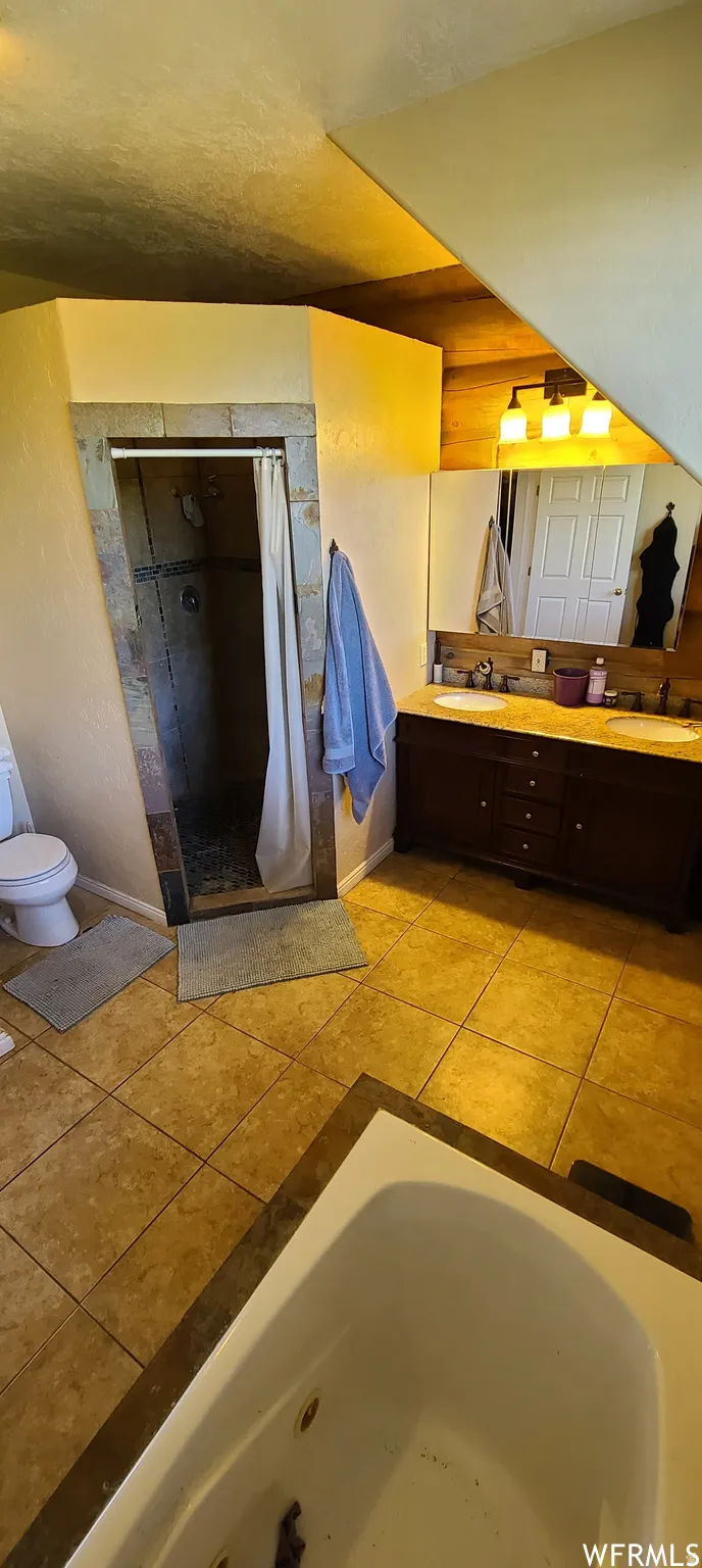 Full bath featuring double vanity, curtained shower, and light tile patterned floors