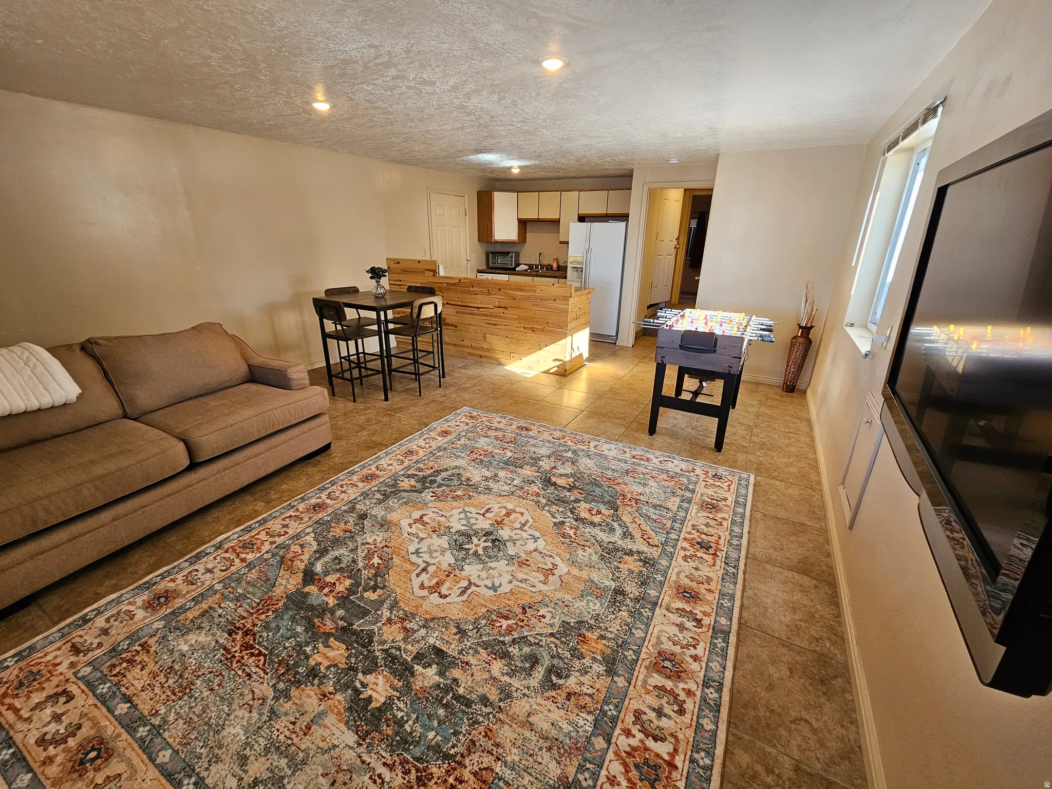 Living room featuring light tile patterned floors and a textured ceiling