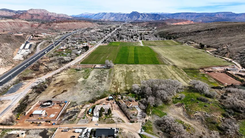 Aerial view of sparsely populated area featuring a mountainous background and abundant farmland