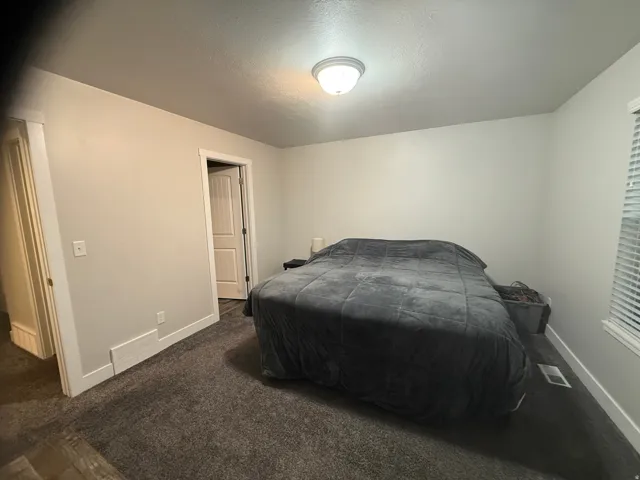 Bedroom with dark carpet and a textured ceiling