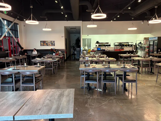 Dining space featuring rail lighting, finished concrete floors, and a high ceiling