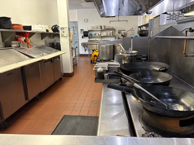 Kitchen with open shelves, stainless steel counters, and dark wood finish cabinets