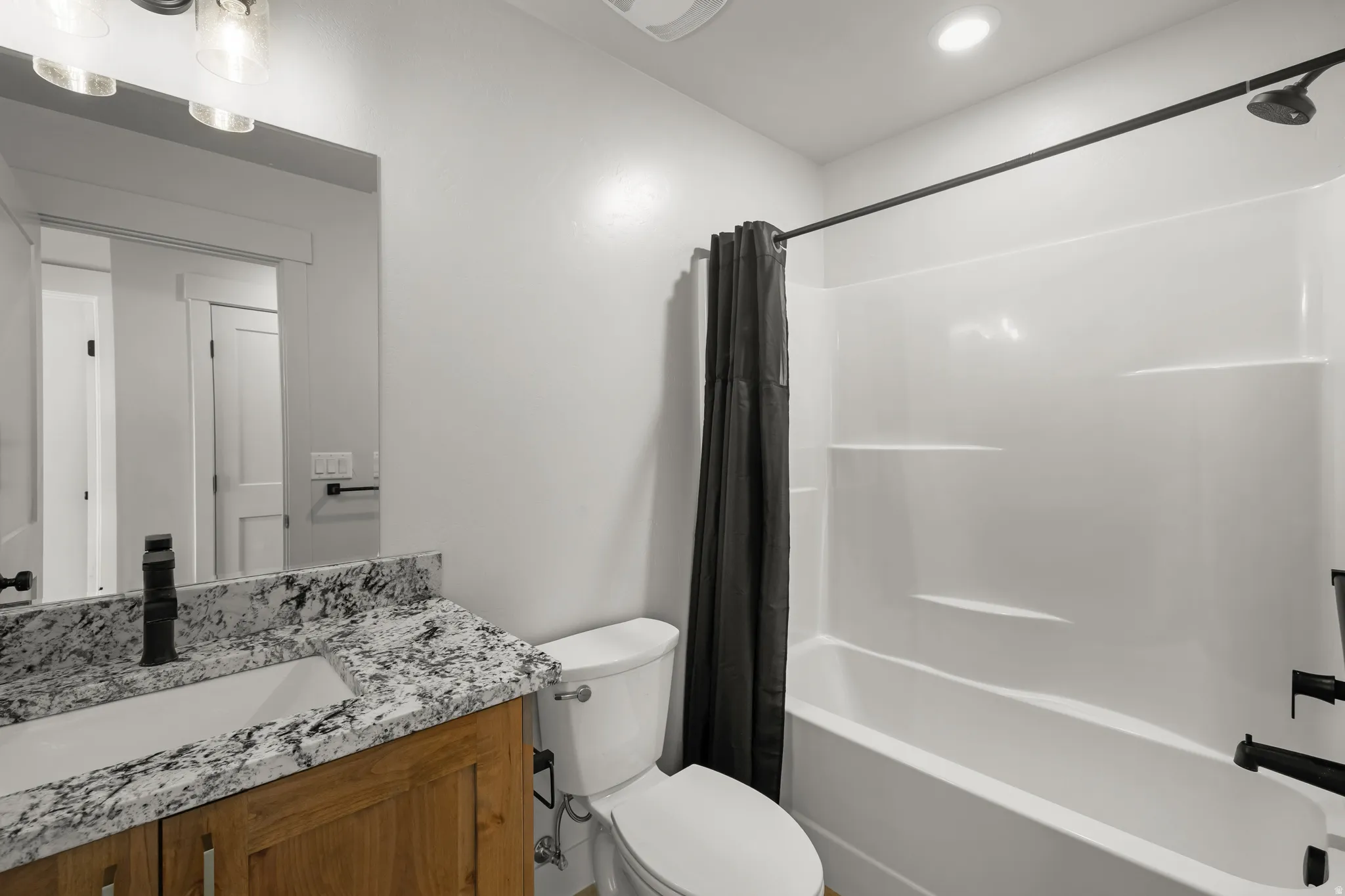 Shared hall bathroom featuring shower / bath combo and vanity