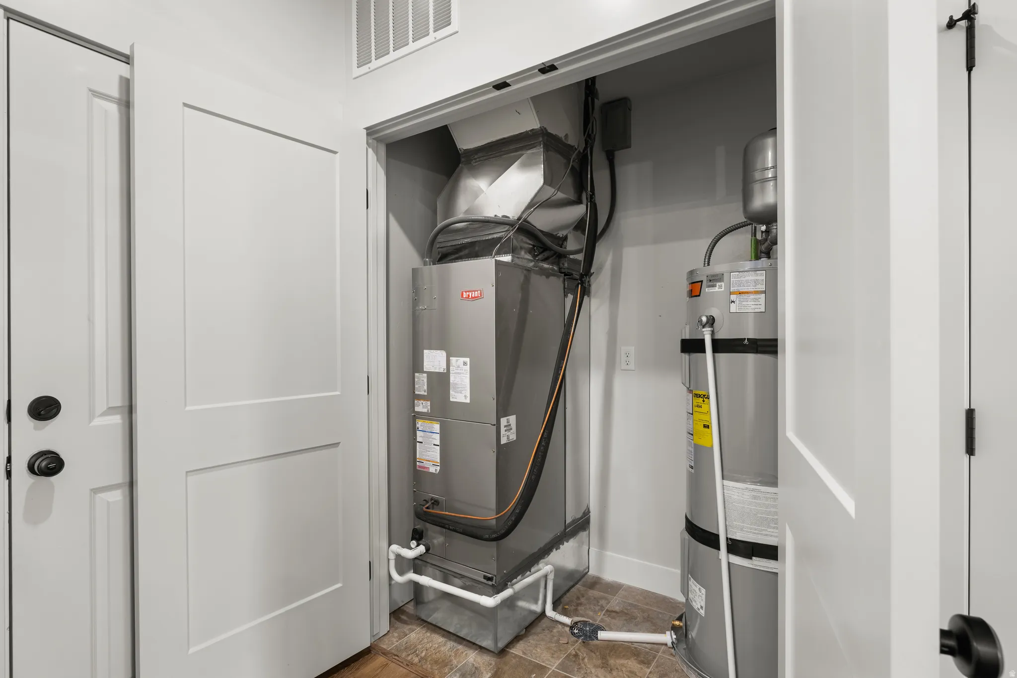 Utility room with secured water heater and heating unit