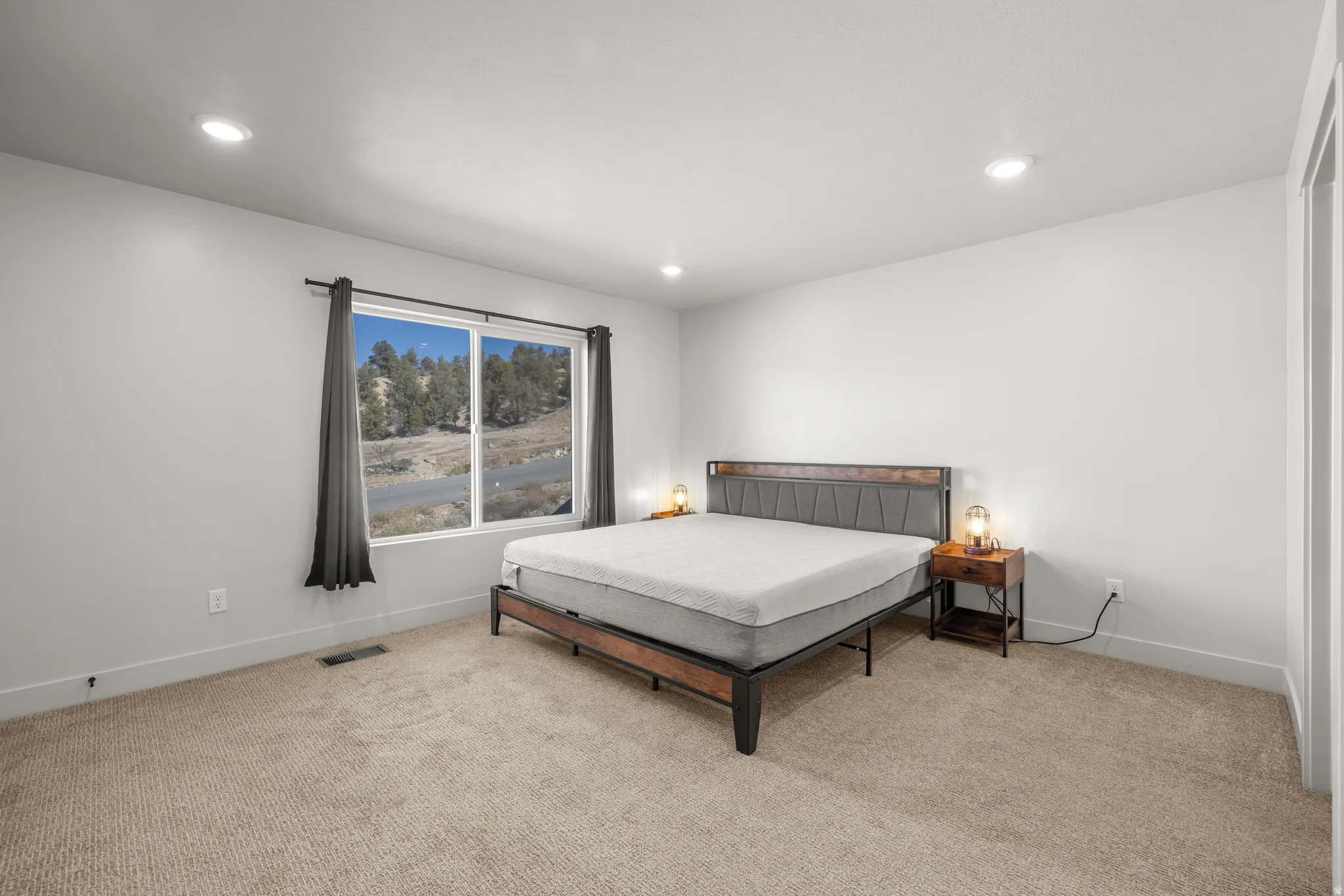 Primary bedroom featuring light carpet and recessed lighting