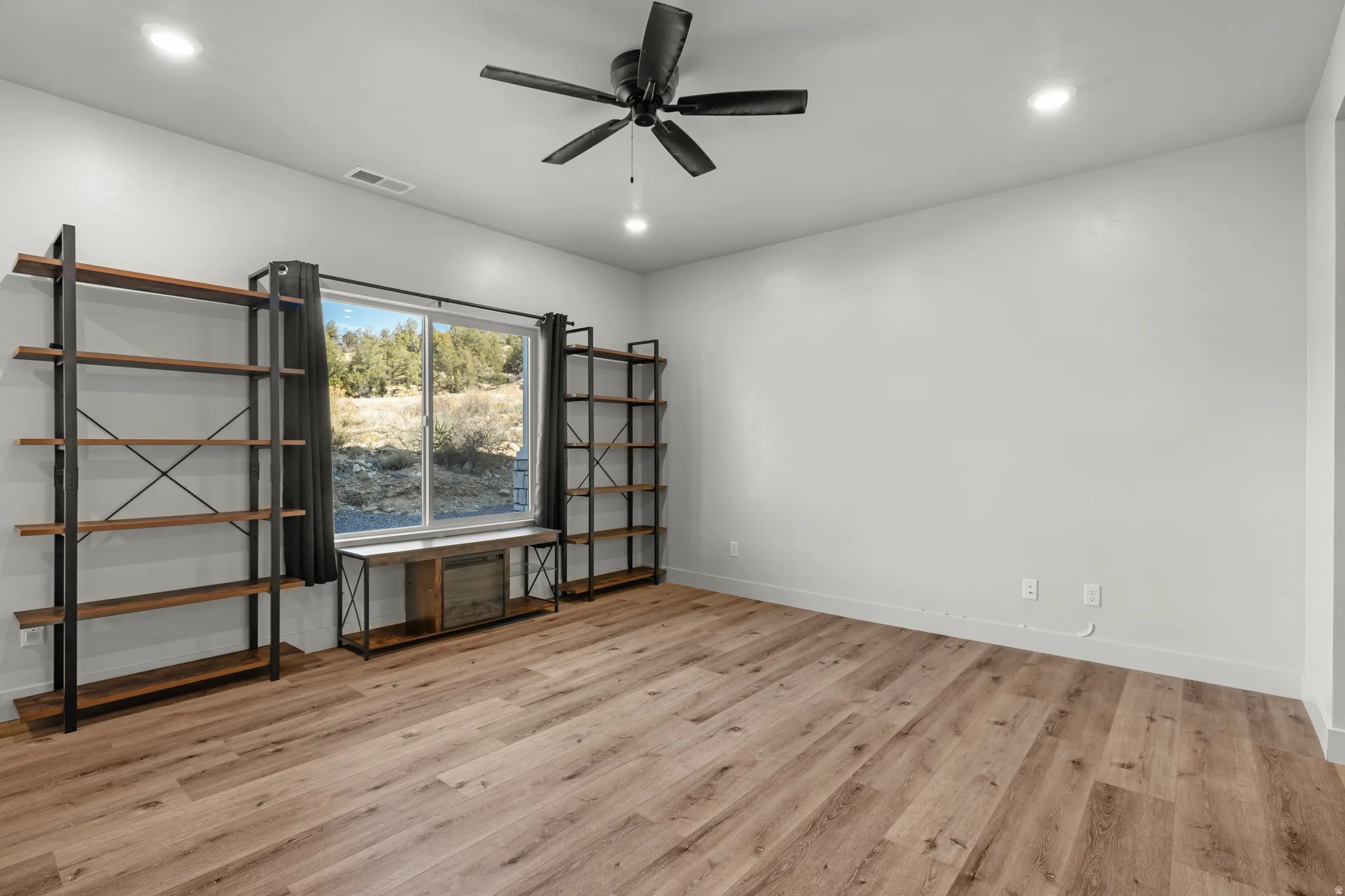 Empty room featuring a ceiling fan, recessed lighting, and light wood finished floors