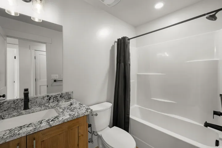 Shared hall bathroom featuring shower / bath combo and vanity