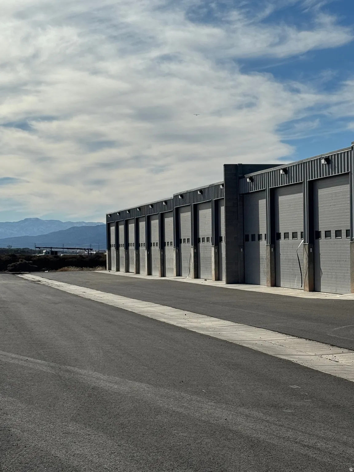 View of building exterior featuring community garages and a mountain view
