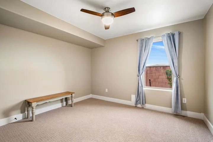 Empty room with ceiling fan and light colored carpet