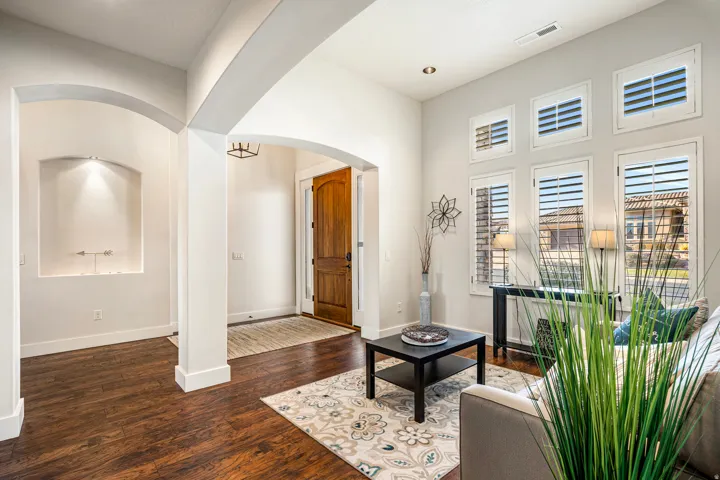 Living area with arched walkways and dark wood finished floors