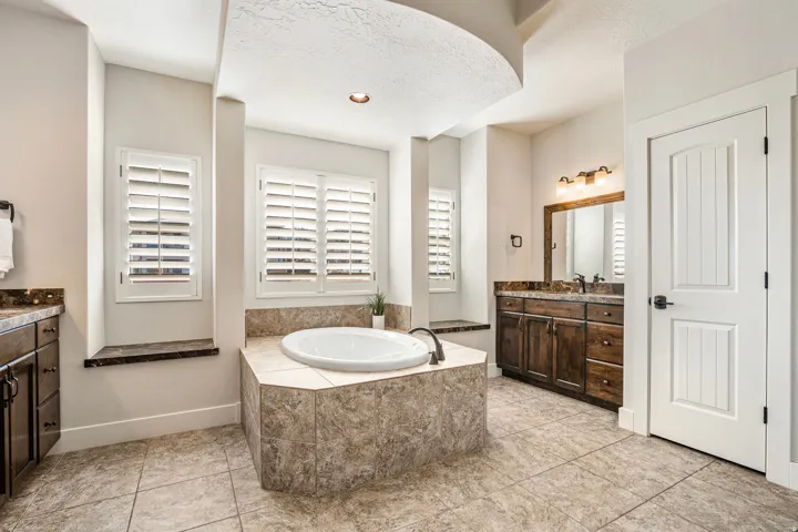 Bathroom featuring a bath, vanity, and a textured ceiling
