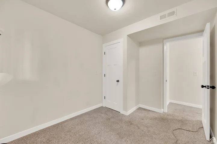 Carpeted empty room featuring baseboards
