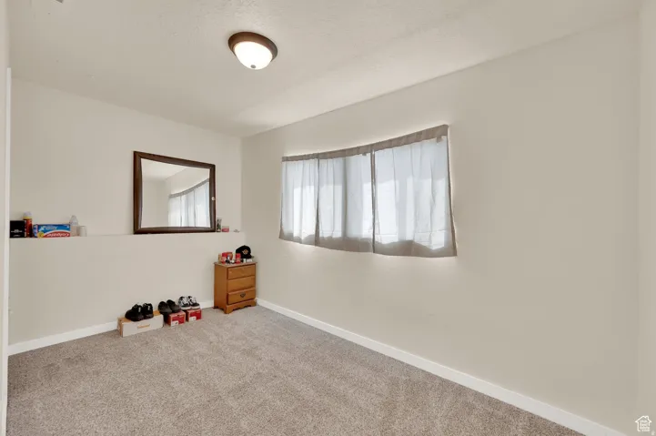 Carpeted spare room with baseboards and a textured ceiling