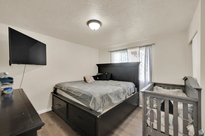Bedroom featuring a textured ceiling and wood finished floors