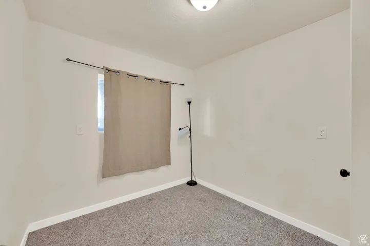 Spare room with baseboards and carpet