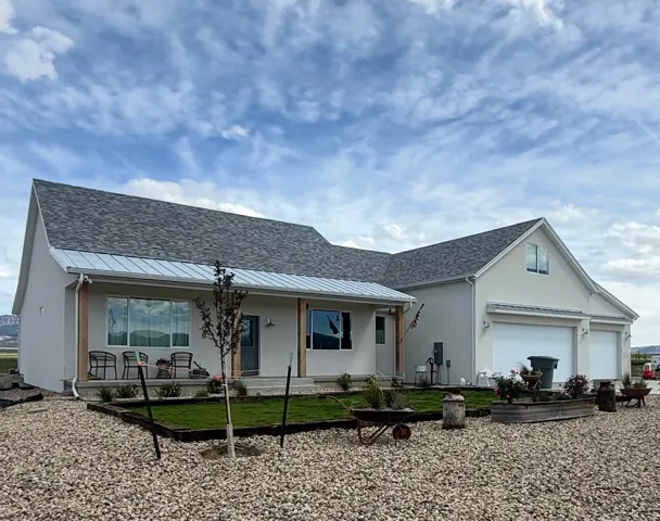 Contemporary stucco exterior with a gray asphalt shingle roof