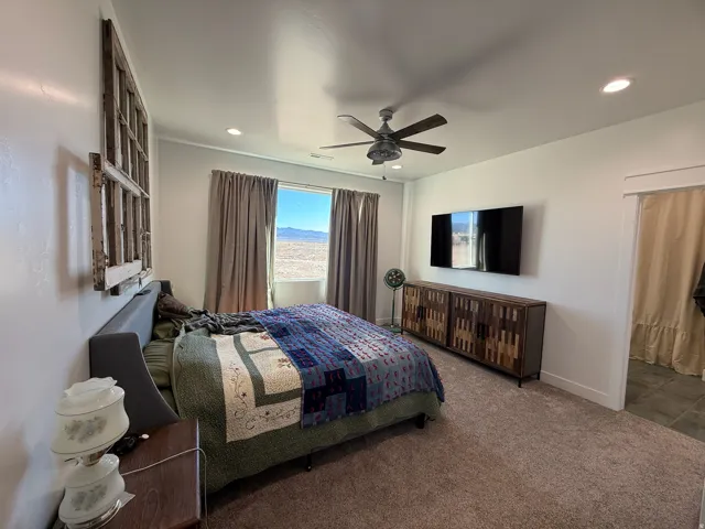 Spacious room featuring a ceiling fan, recessed lighting, and a large window with distant mountain scenery