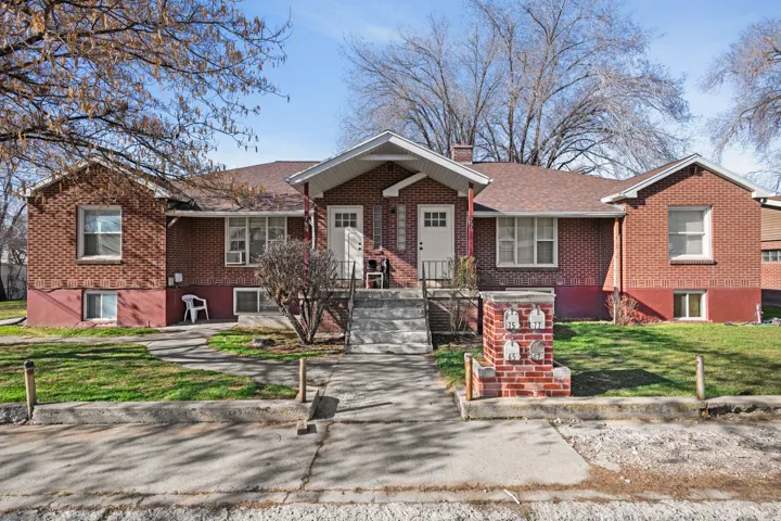 Single story home featuring brick siding, a front yard, and a chimney