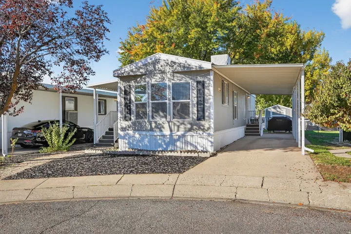 Manufactured / mobile home with driveway and an attached carport
