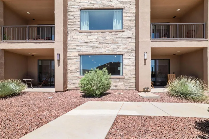 Exterior space featuring stone siding, stucco siding, and a patio area