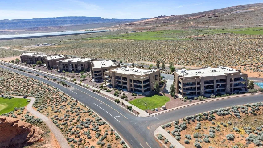 Drone / aerial view of a mountain backdrop and apartment complex / building