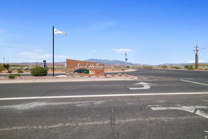 View of asphalt road featuring street lighting, curbs, and a mountain view