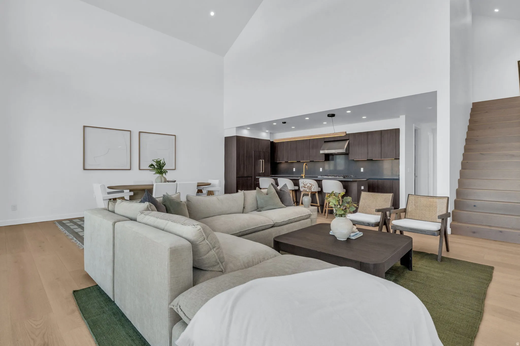Living area featuring light wood-type flooring, recessed lighting, and vaulted ceiling