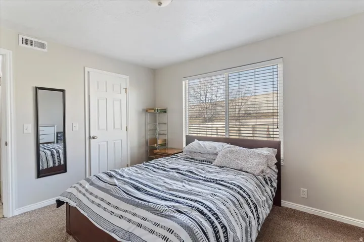 Bedroom featuring baseboards and light carpet