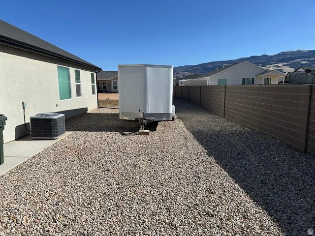 Fenced backyard featuring a residential view, a mountain view, and an outbuilding