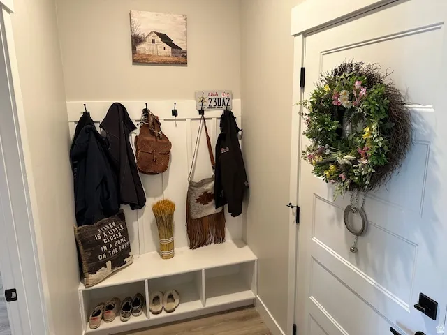 Mudroom featuring light wood-style flooring and baseboards