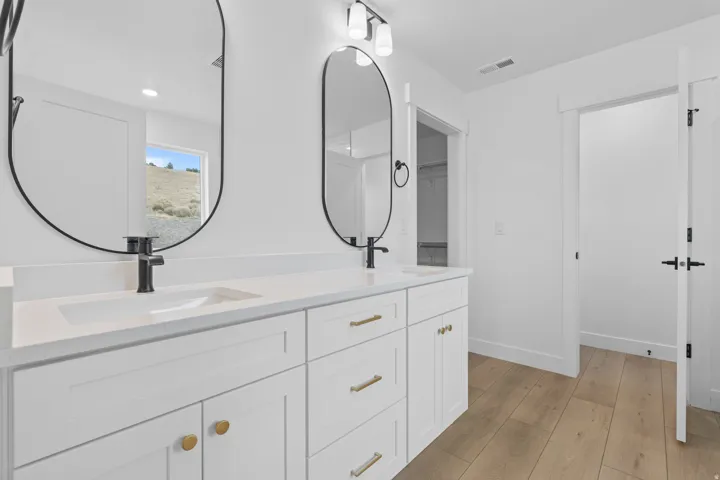 Full bathroom featuring light wood-type flooring, double vanity, and recessed lighting