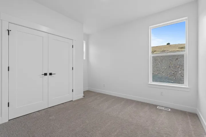 Unfurnished bedroom featuring carpet and a closet